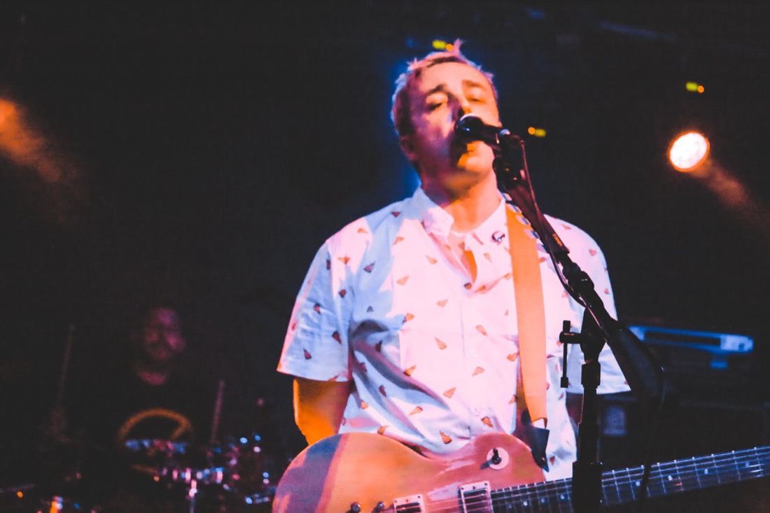 Steven Schopp singing and playing guitar on stage